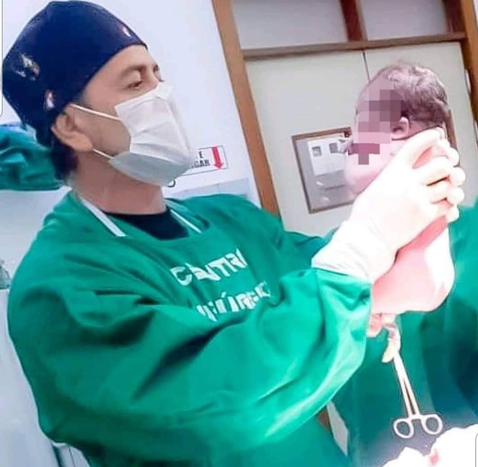 Médico foi fotografado enquanto conversava com bebê que havia acabado de nascer  — Foto: Arquivo pessoal 