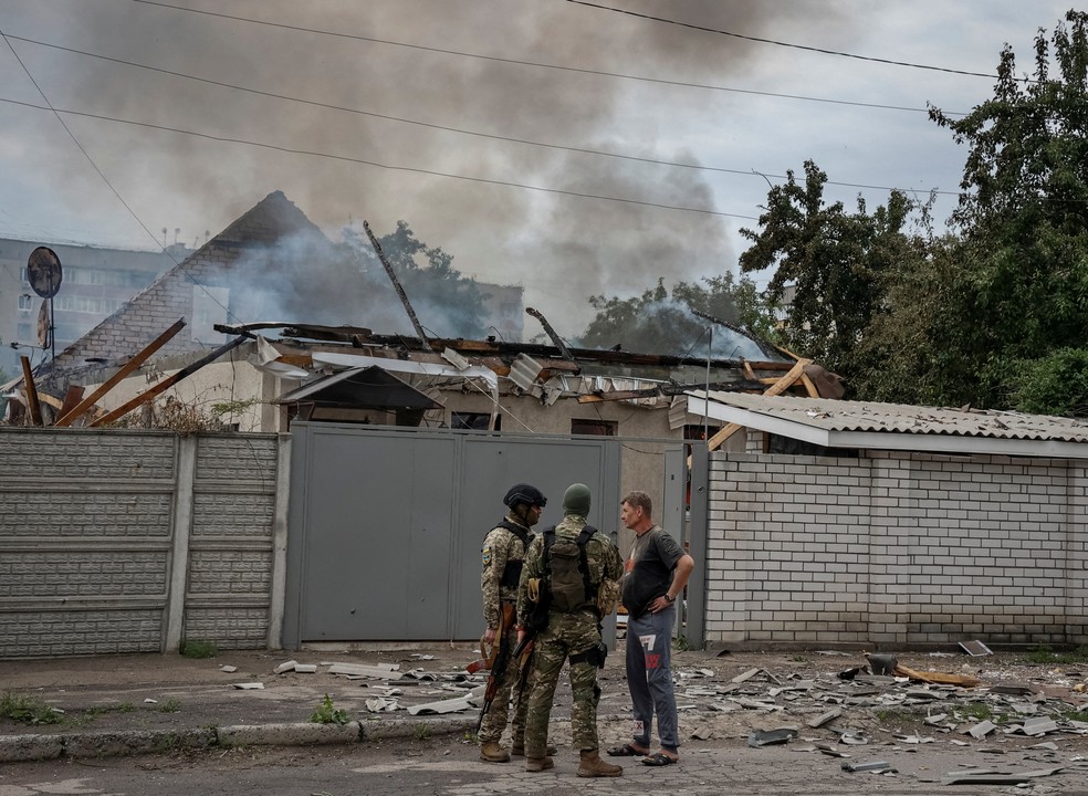 Soldados ucranianos conversam com morador que teve a casa atingida por bombardeio russo em Luhansk, em 3 de junho de 2022 — Foto: Serhii Nuzhnenk/ Reuters