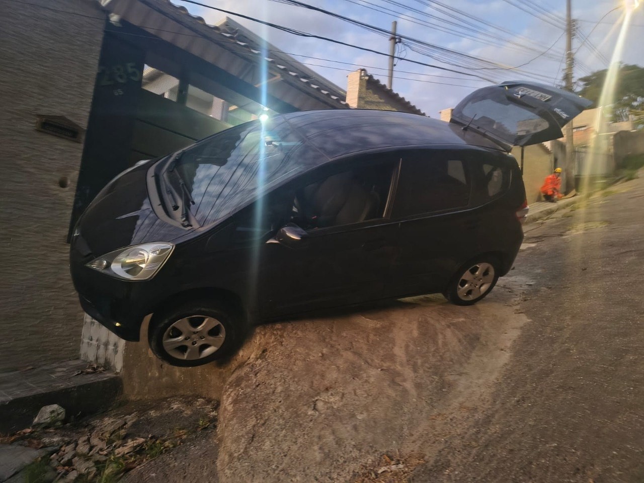 Carro fica dependurado sobre pedra após motorista perder controle da direção; VÍDEO