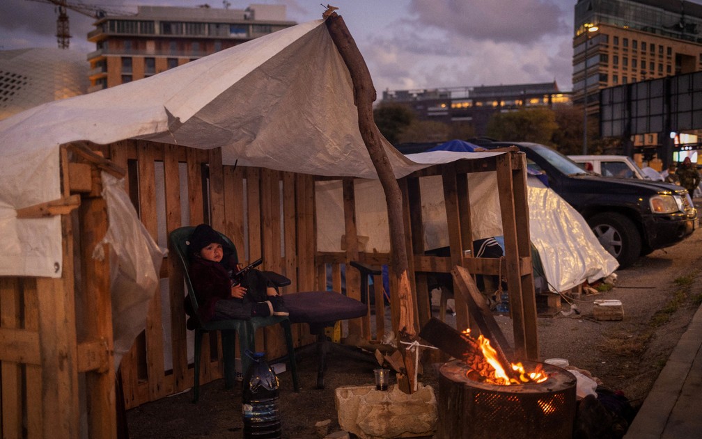 Menino se senta ao lado do fogo em uma tenda, em um acampamento temporário para pessoas deslocadas em Beirute, Líbano, 30 de março de 2026. — Foto: Adnan Abidi/Reuters