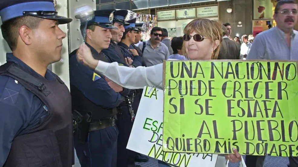 No início de 2002, milhares de argentinos bateram enfurecidos nas portas dos seus bancos, exigindo. a retirada de suas economias, — Foto: Getty Images via BBC