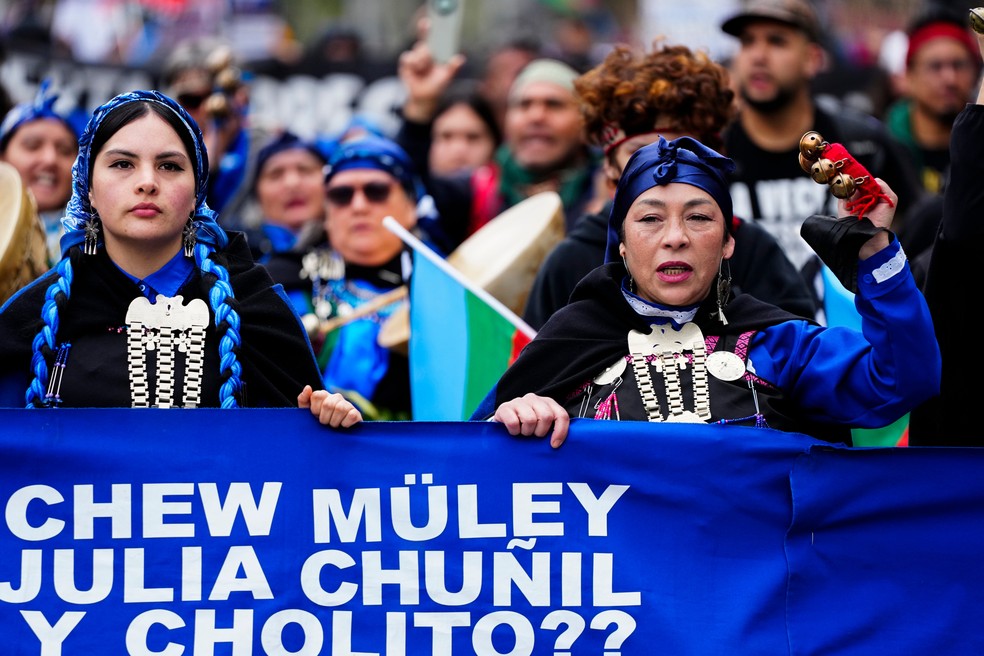 Membros de grupos indígenas e de organizações sociais marcham em defesa dos direitos à terra, da igualdade e da proteção das comunidades indígenas, em Santiago, no Chile, na segunda-feira, 12 de outubro de 2026. — Foto: Esteban Felix/AP
