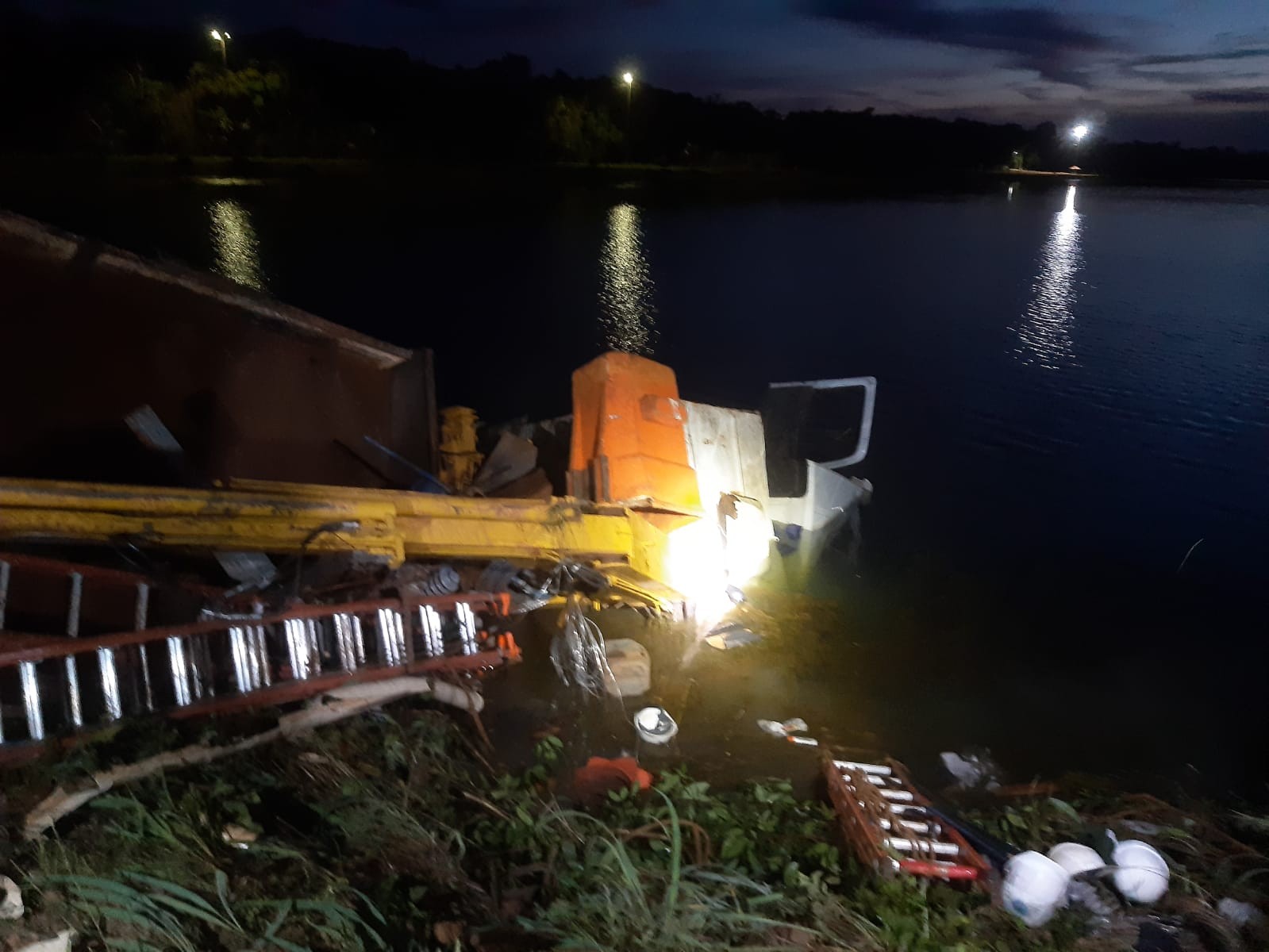 Funcionário morre e 4 ficam feridos após caminhão capotar e parar em lago às margens da BR-364 em MT