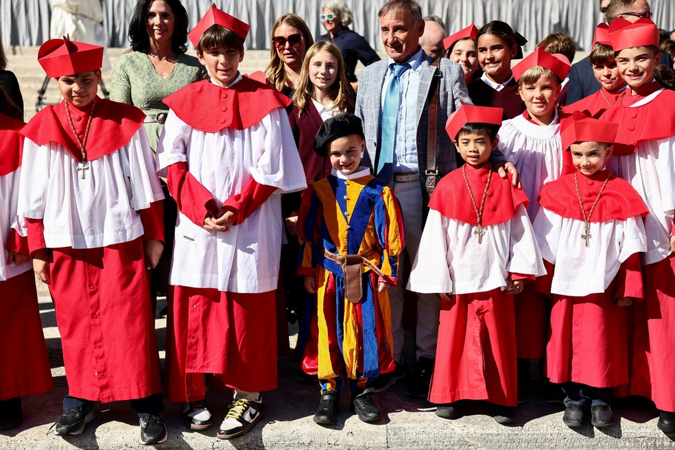 Estudantes de escola católica de Chicago vestidas como cardeais e guarda suíço durante visita ao Vaticano, em 8 de outubro de 2025. — Foto: Yara Nardi/ Reuters