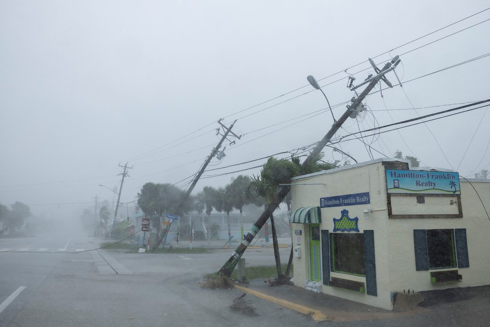 Postes de energia quebrados e derrubados por rajadas de vento enquanto o furacão Milton se aproxima de Fort Myers, na Flórida — Foto: REUTERS/Ricardo Arduengo