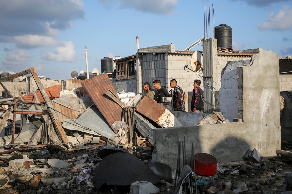 Palestinos observam destroços de casa destruída no conflito entre Israel e o Hamas em Rafah, na fronteira da Faixa de Gaza com o Egito, nesta terça-feira (7) — Foto: Hatem Khaled/Reuters