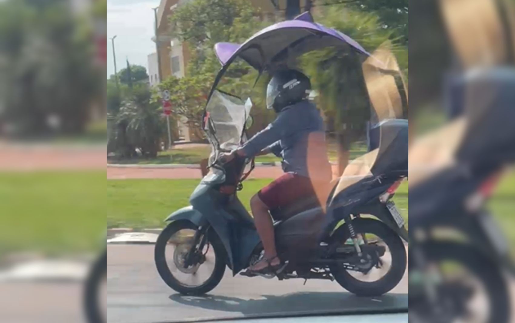 Mulher chama a atenção após usar guarda-sol na moto para tentar escapar do calor no trânsito de Goiânia; vídeo