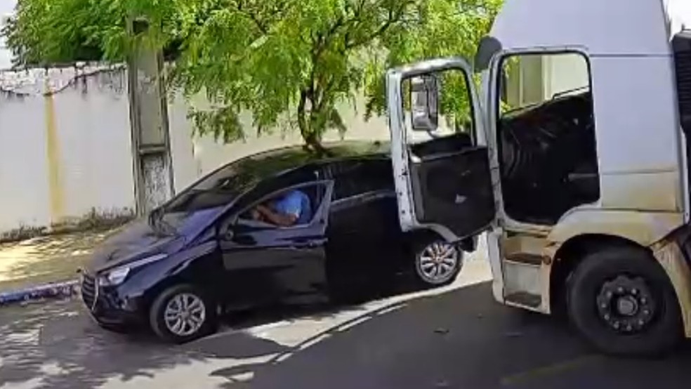 Caminhoneiro destrói vidro de carro e tira veículo de estacionamento regular para dar passagem a caminhão — Foto: Reprodução