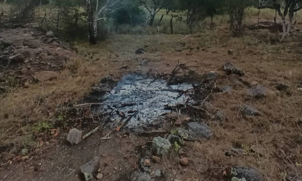 Fogueira com vestígios de roupas incineradas e um celular quebrado, que pertencia a uma das vítimas — Foto: Ascom/PC-BA