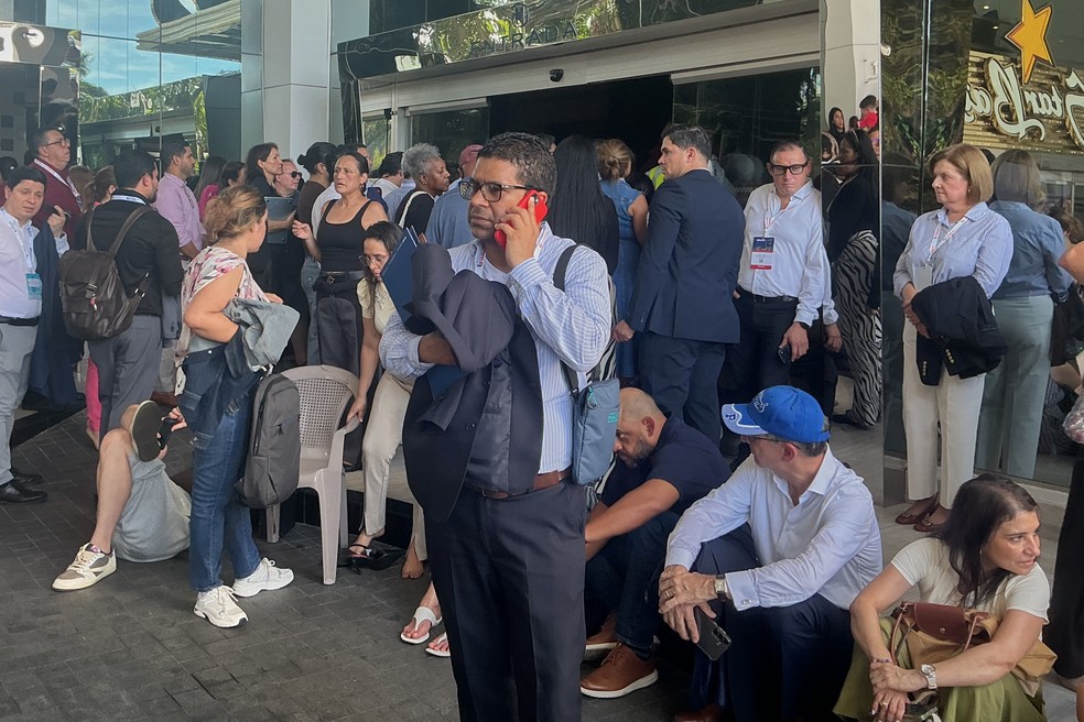 Pessoas observam a paisagem do lado de fora de um prédio após um terremoto atingir a Cidade do Panamá, na sexta-feira, 9 de outubro de 2026. — Foto: AP/Alma Solis