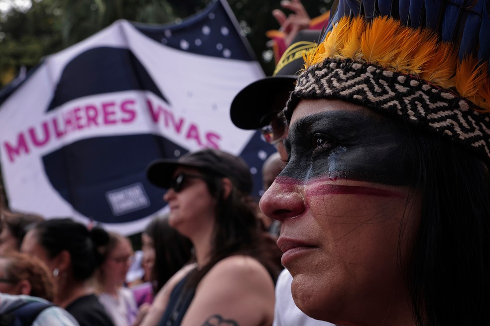 Uma mulher indígena chora durante uma marcha contra o feminicídio após uma série de casos de grande repercussão no país, em São Paulo, domingo, 7 de dezembro de 2025. — Foto: AP/Ettore Chiereguini