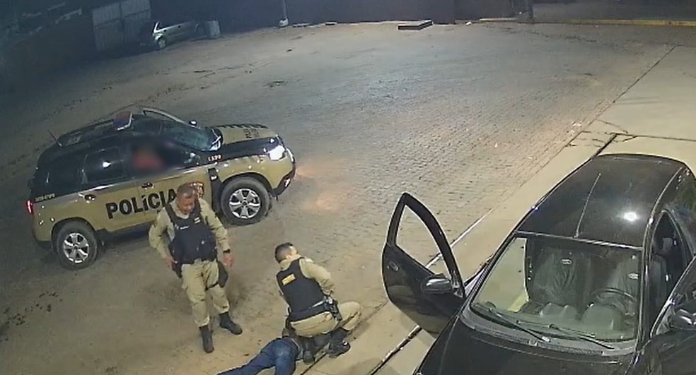 Mulher sequestrada já dentro da viatura da PM e agressor imobilizado pela PM — Foto: Câmeras de segurança