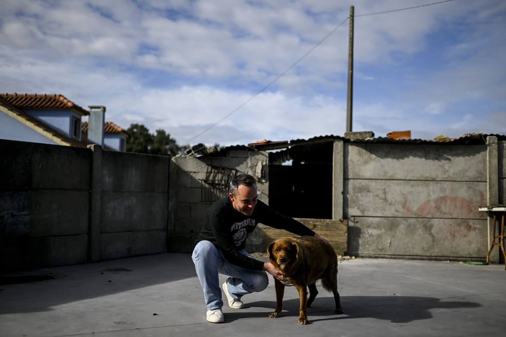 Leonel Costa brinca com seu cão Bobi em Conqueiros, no interior de Portugal — Foto: PATRICIA DE MELO MOREIRA/AFP