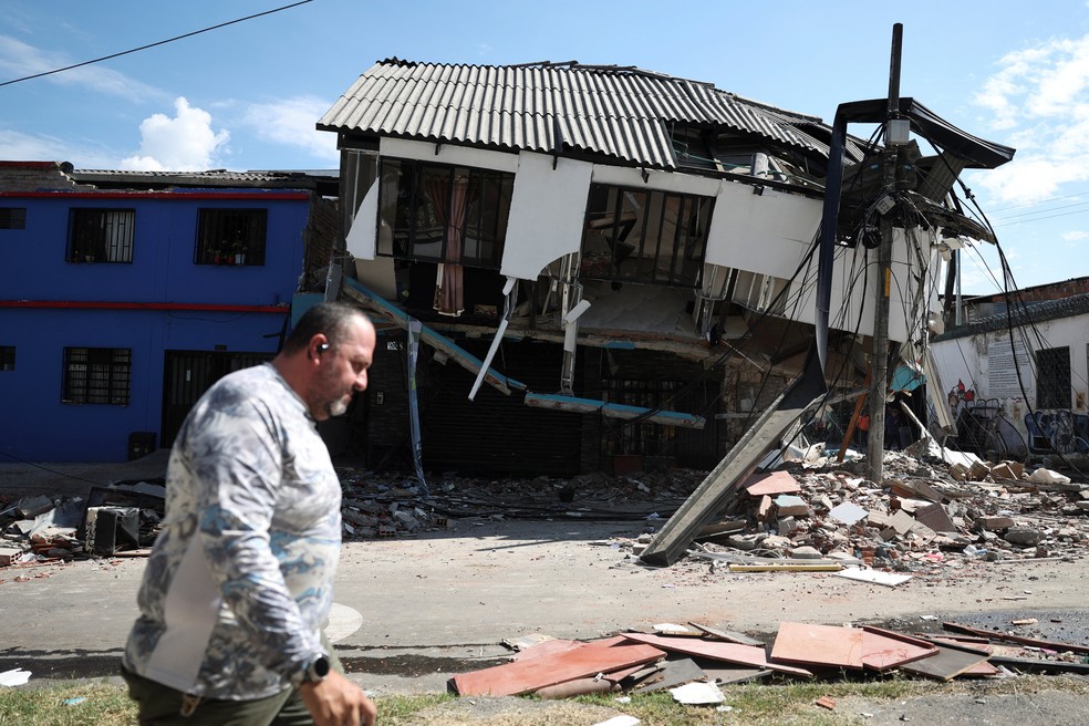 Homem caminha diante de casa parcialmente destruída em Pereira, na Colômbia, em decorrência do terremoto que atingiu o país, 13 de agosto de 2026. — Foto: Luisa Gonzalez/ Reuters