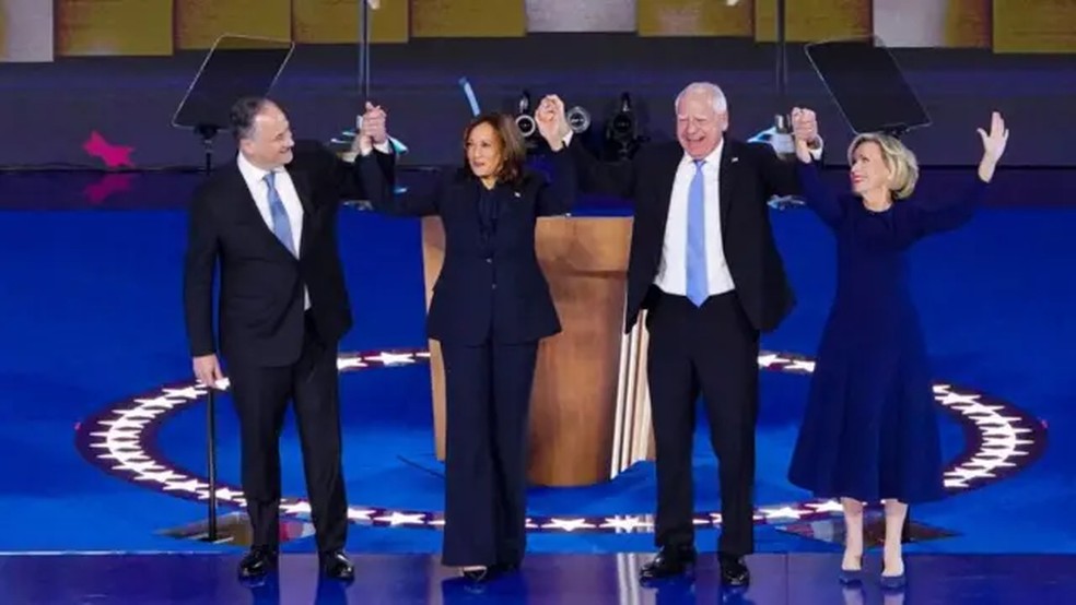 Kamala Harris e seu marido Doug Emhoff de mãos dadas com Tim Walz e sua esposa Gwen Walz, durante a Convenção Nacional Democrata — Foto: Getty Images/via BBC