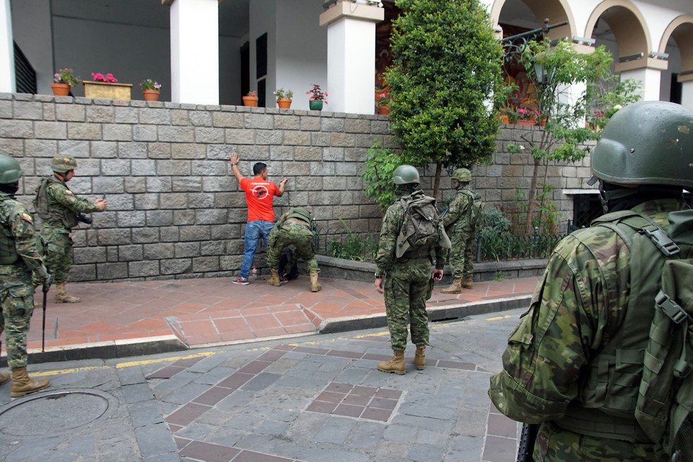 Soldados revistam homem nas ruas de Cuenca, no Equador — Foto: Fernando Machado/AFP