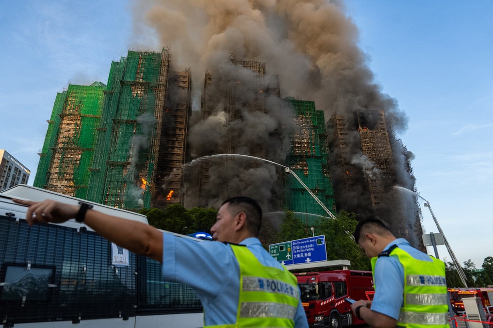 Os prédios estavam em obras, com andaimes feitos de bambu na fachada e lonas — Foto: AP Photo/Chan Long Hei