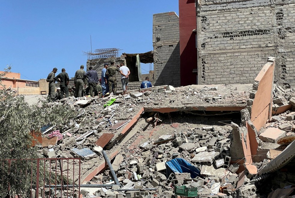 Equipes de resgate marroquinas estão sobre os escombros de um prédio danificado enquanto procuram sobreviventes na vila de Amizmiz, após um poderoso terremoto no Marrocos, em 9 de setembro de 2023 — Foto: Ahmed El Jechtimi/ Reuters