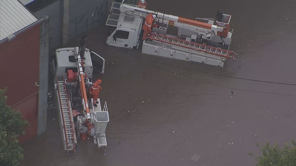 Funcionários da Enel no meio de alagamento da Rua Dom Lucas Obes, no Ipiranga — Foto: Rede Globo