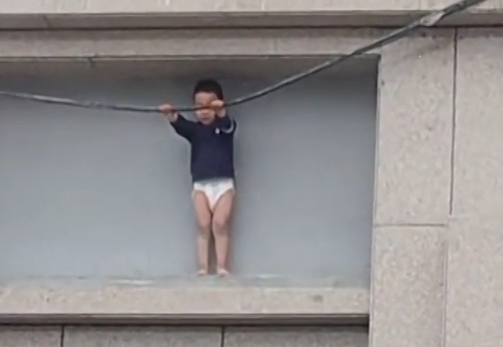 Menino ficou preso do lado de fora de prédio na China — Foto: Viral Press via Reuters Connect