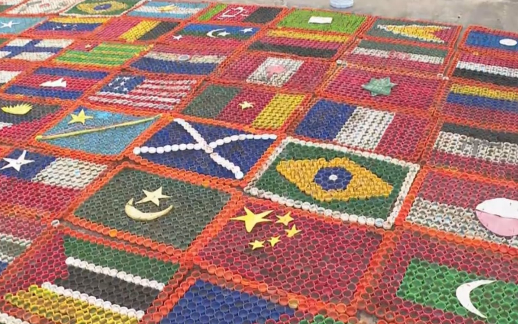 Artista utiliza tampinhas de garrafas PET para criar bandeiras dos países que disputam a Copa do Mundo