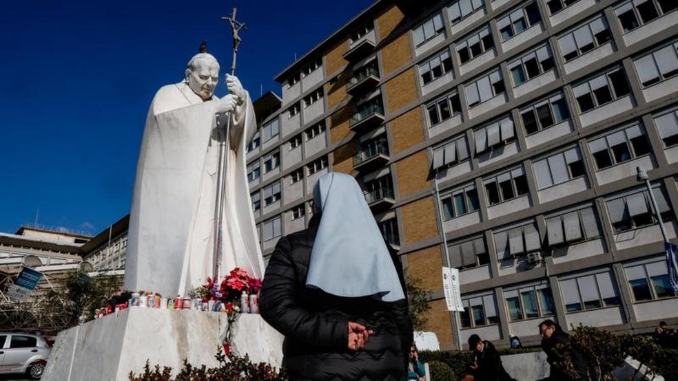 Uma estátua do falecido Papa João Paulo 2º fica do lado de fora do Hospital Gemelli, onde o Papa Francisco está recebendo tratamento médico — Foto: Reuters
