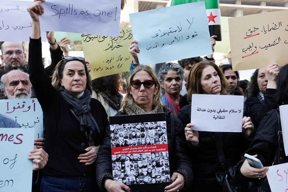 Pessoas protestam contra o assassinato de civis e forças de segurança ligadas aos novos governantes da Síria, após confrontos entre as forças leais à nova administração e combatentes da seita alauíta de Bashar al-Assad, na Praça Marjeh, em Damasco, Síria, 9 de março de 2025. — Foto: REUTERS/Khalil Ashawi