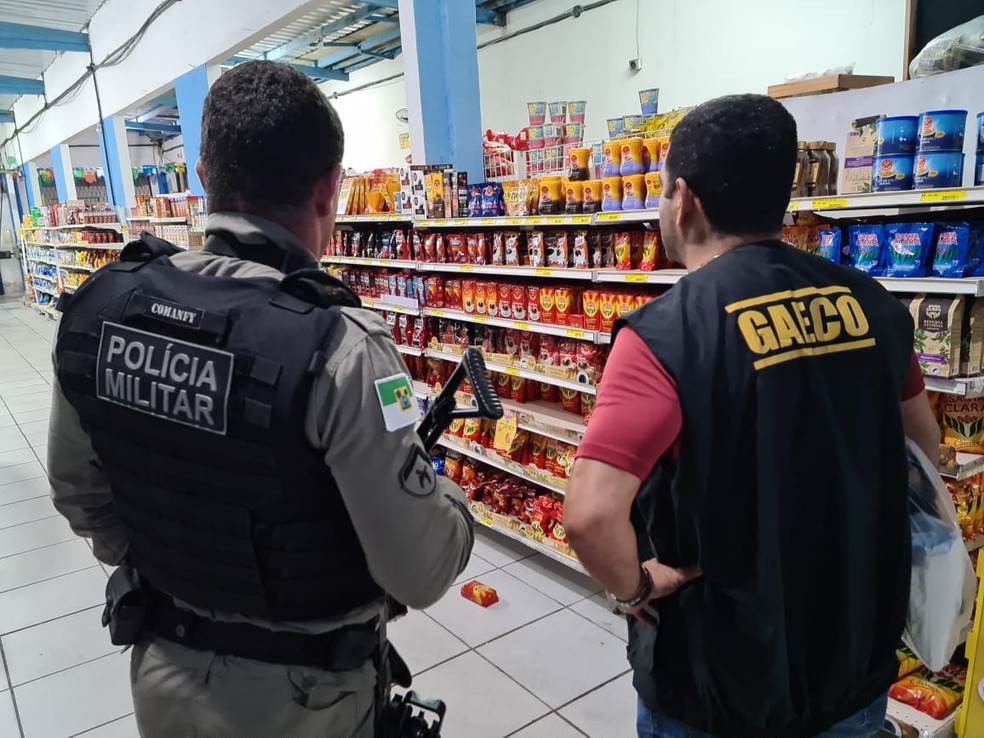 Policial militar ao lado de servidor do MP, em operação que investiga sonegação fiscal no RN — Foto: MPRN/Divulgação