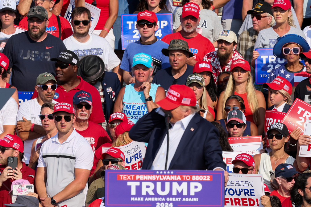 Donald Trump leva mão à orelha assim que começam os sons de tiros em comício — Foto: REUTERS/Brendan McDermid