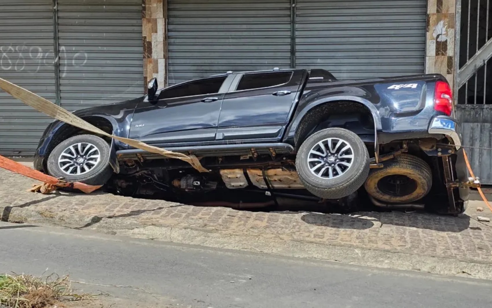 Carro estacionado cai em cratera após asfalto ceder na BR-420, em Mutuípe