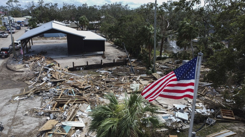 Bandeira dos EUA em meio a destruição causada pelo furacão Helene em Horseshoe Beach, na Flórida — Foto: AP Photo/Stephen Smith