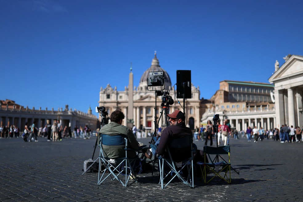 Jornalistas aguardamem frente à Basílica de São Pedro, no Vaticano, em 12 de outubro de 2026. — Foto: Yara Nardi/ Reuters