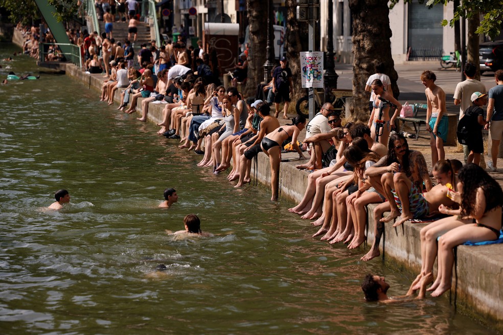 Franceses às margens do Canal Saint-Martin, em Paris, onde o banho foi liberado — Foto: REUTERS/Alice Sacco