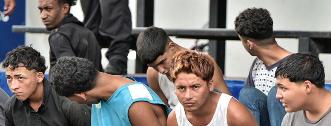 Imagem de homens que foram detidos pela polícia por terem invadido um estúdio de TV no Equador — Foto: Vicente Gaibor del Pino/Reuters