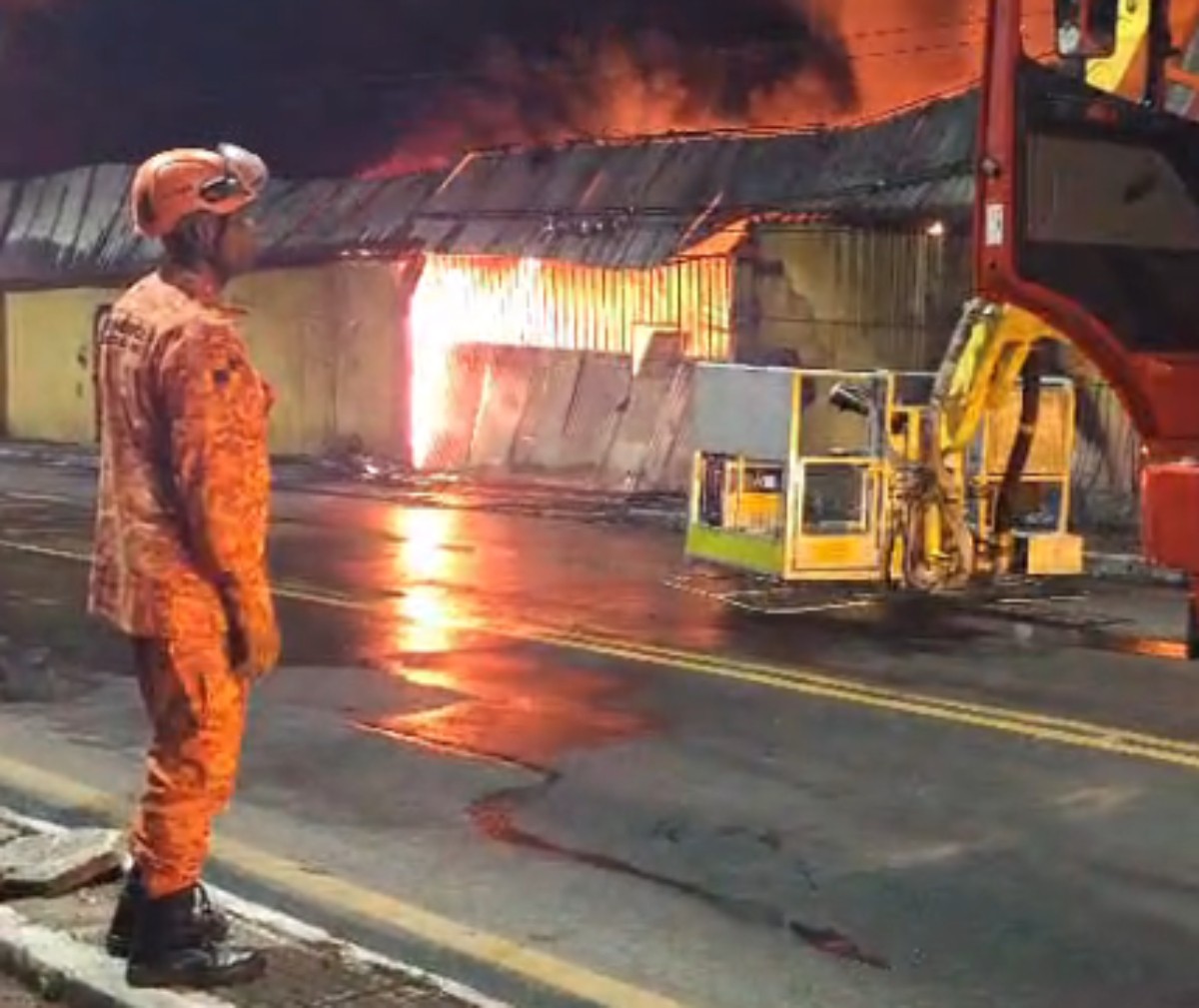 Vídeo mostra moradores ajudando idoso a sair de casa próxima a incêndio em loja de pneus em Volta Redonda