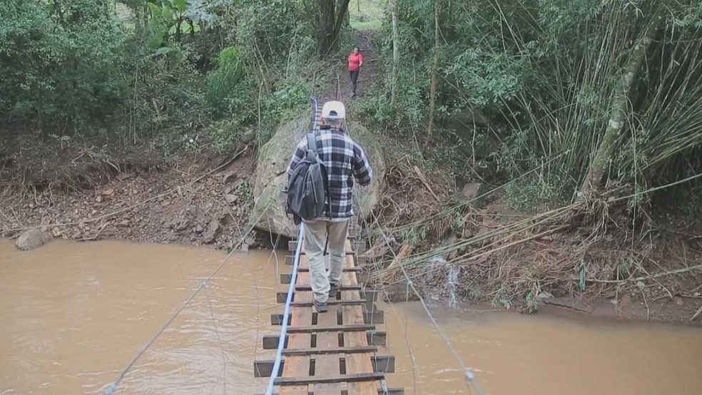 Comunidade constrói ponte provisória para acessar área alagada — Foto: Reprodução/RBS TV