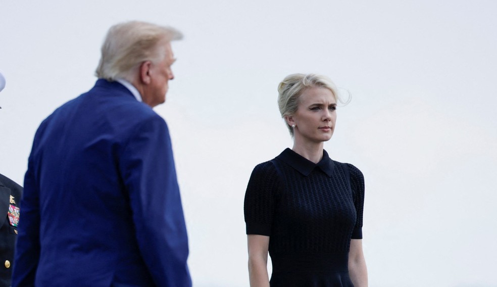 Assessora Natalie Harp próxima ao presidente dos Estados Unidos, Donald Trump, em base aérea. Foto de julho de 2026. — Foto: REUTERS/Evan Vucci