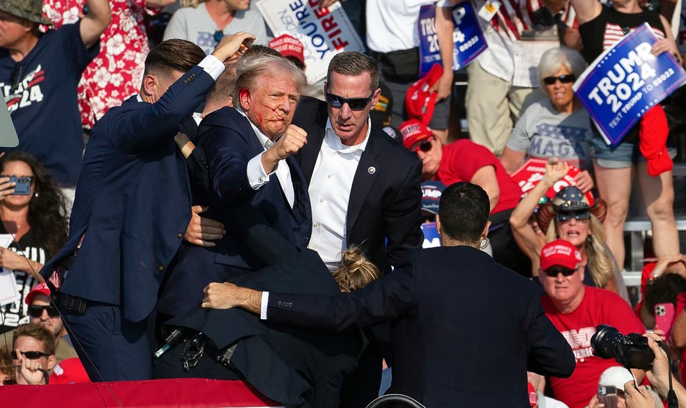 Donal Trump com ferimento após tiros em comício na Pensilvânia — Foto: Rebecca DROKE / AFP