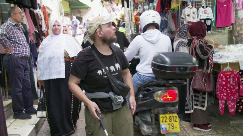 Giles passeia sozinho por mercado de Jerusalém — Foto: BBC