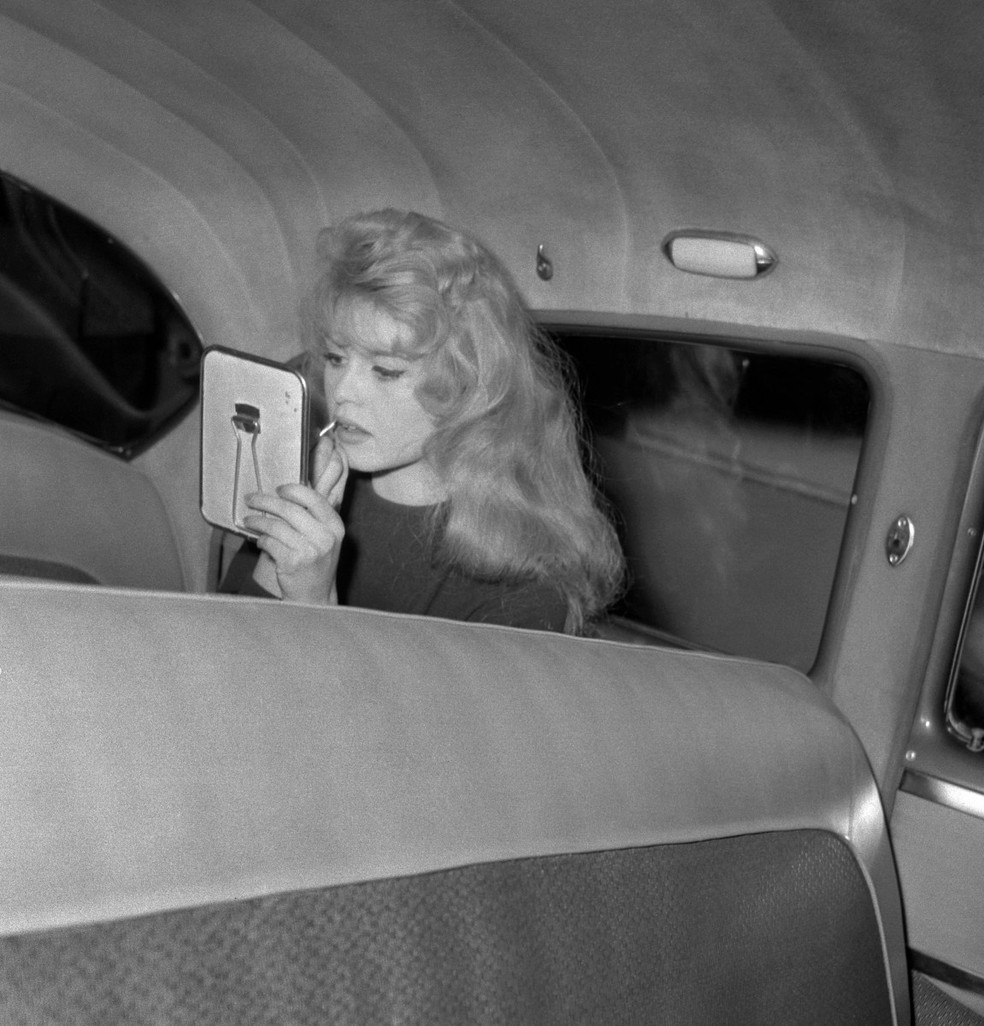 Brigitte Bardot retoca a maquiagem no set de "Amar é Minha Profissão", dirigido por Claude Autant-Lara, em Paris, em 2 de fevereiro de 1958. — Foto: AFP