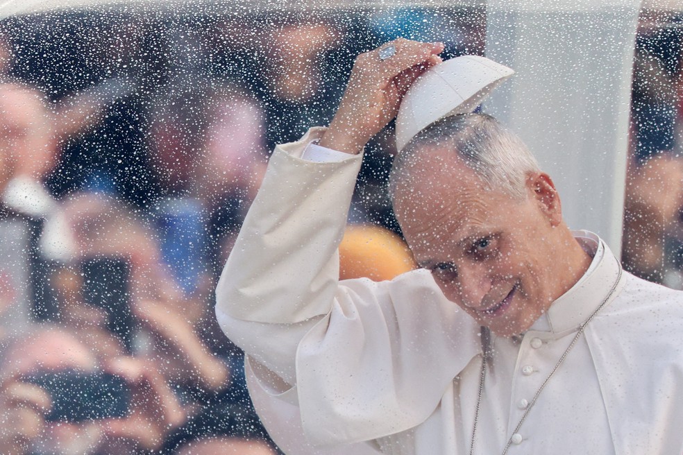 Papa Leão XIV cumprimenta devotos com gesto com solidéu a bordo do papamóvel antes de audiência na Praça de São Pedro, no Vaticano, em 21 de outubro de 2026. — Foto: REUTERS/Yara Nardi