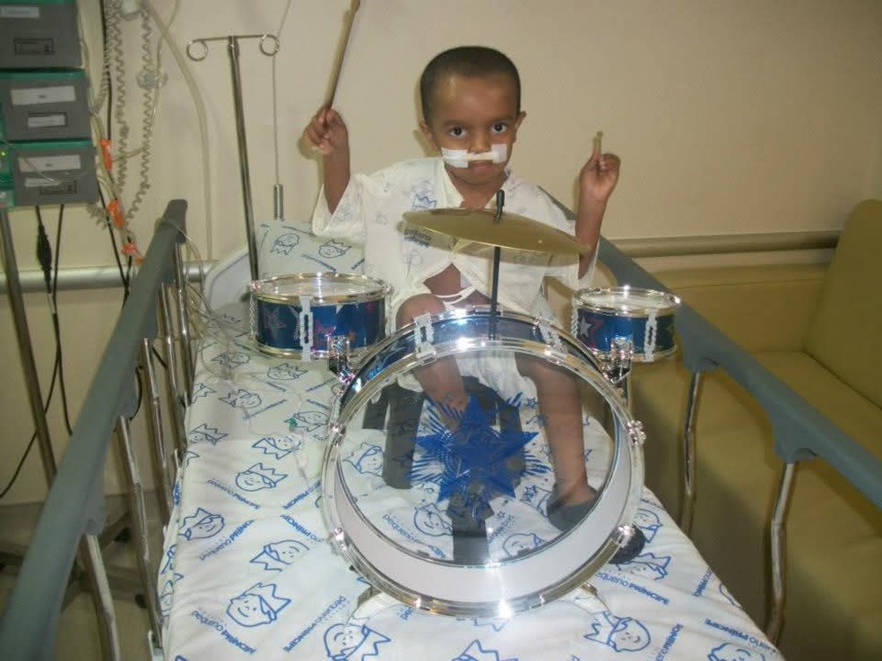 Doutor Eurípides presenteou Robert com uma bateria como forma de aliviar as dificuldades emocionais do tratamento para a criança — Foto: Arquivo Pessoal