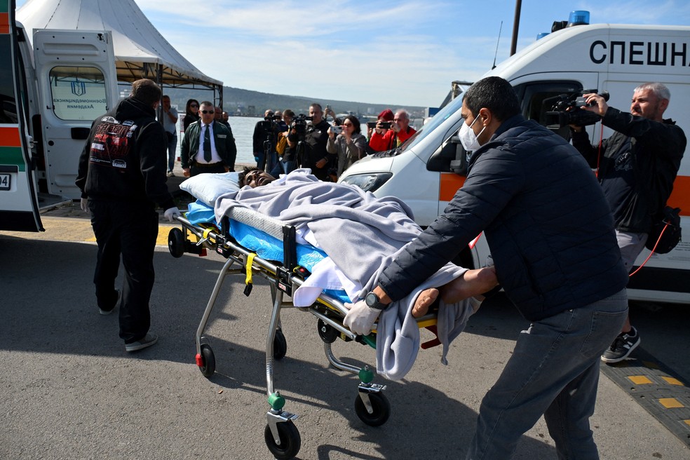 Um tripulante ferido de um navio danificado em um ataque de drone é transportado em uma maca após ser resgatado depois que uma embarcação afundou e outra foi danificada no Mar Negro — Foto: REUTERS/Petko Momchilov