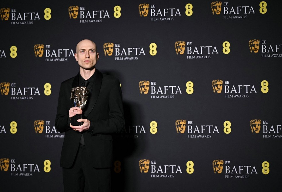 Daniel Blumberg posa com o prêmio BAFTA de melhor trilha sonora original por "O Brutalista" — Foto: Justin Tallis/AFP