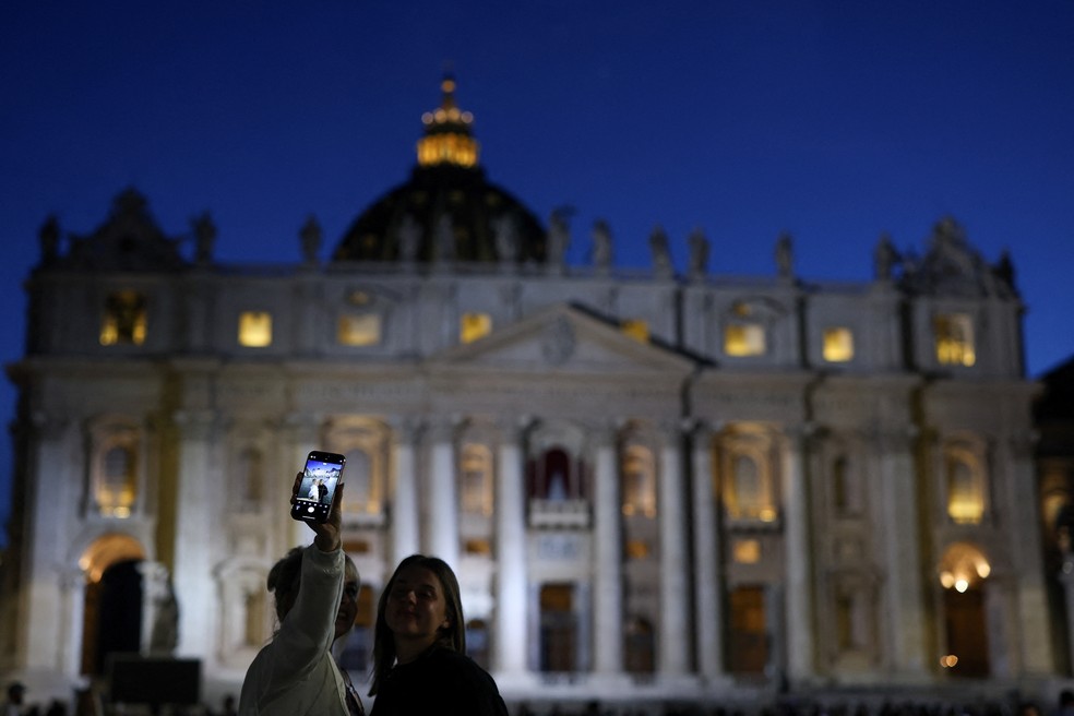 Fiéis em frente à Basílica de São Pedro, onde será anunciado o novo papa — Foto: Amanda Perobelli/Reuters