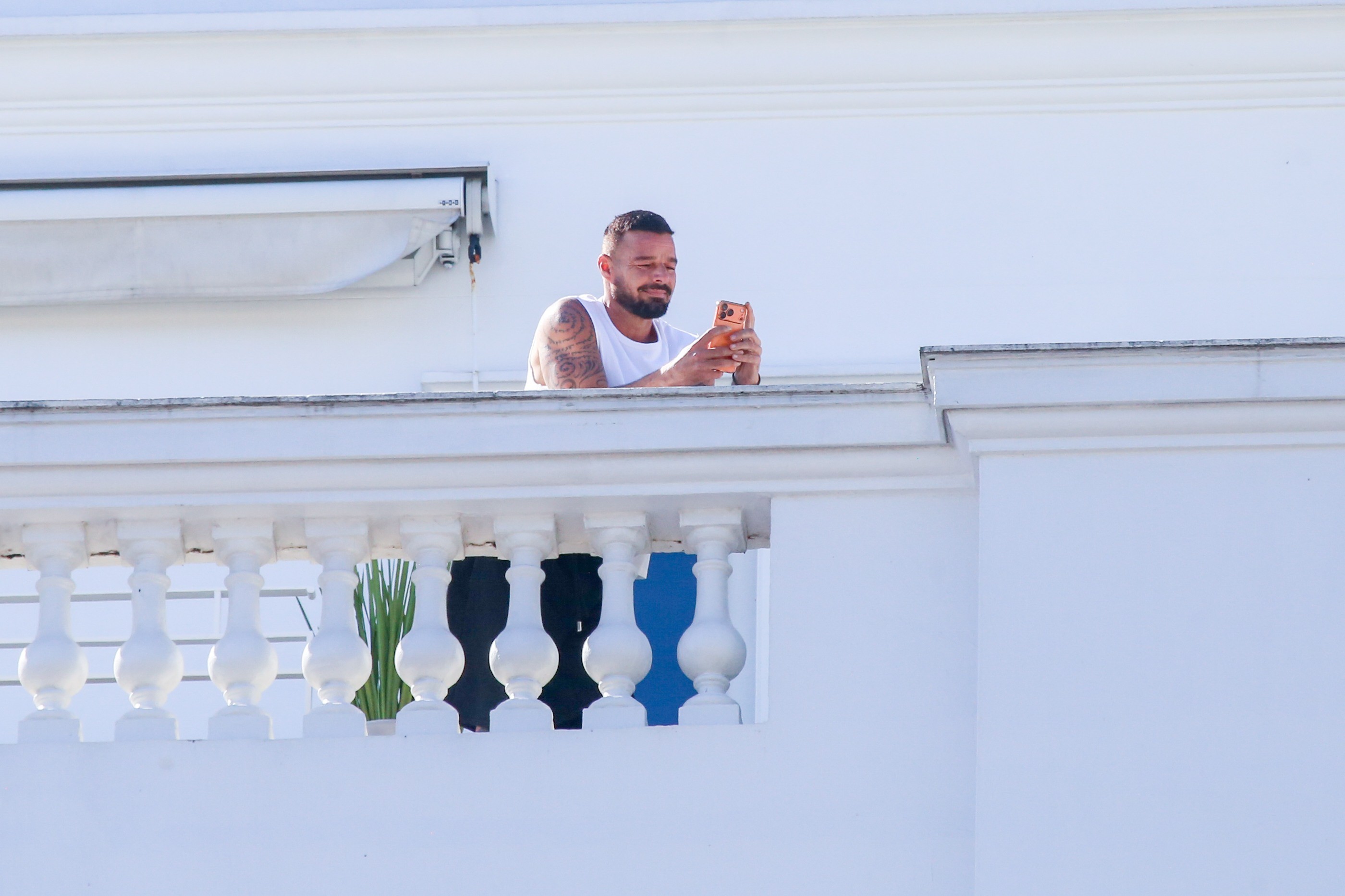 Ricky Martin aparece na sacada de hotel e filma bloco de carnaval