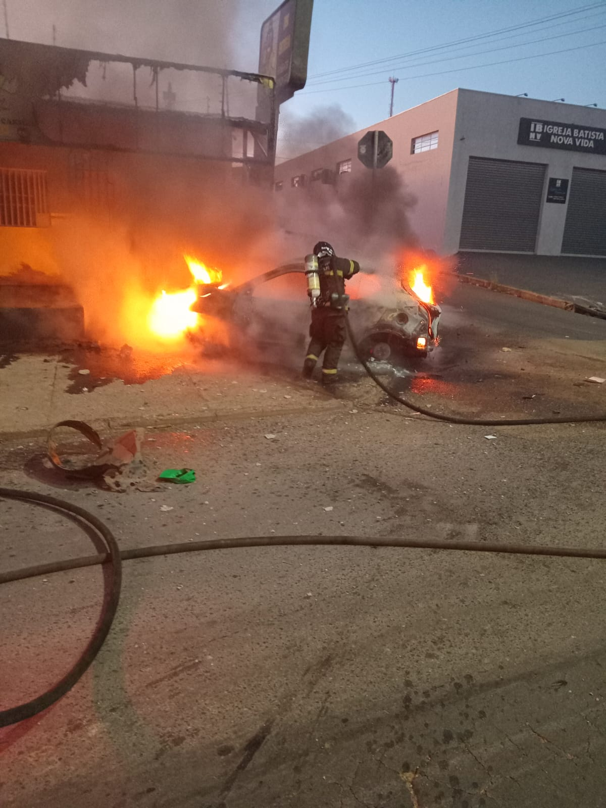 Carro em chamas é abandonado por motorista em frente a distribuidora de Cuiabá