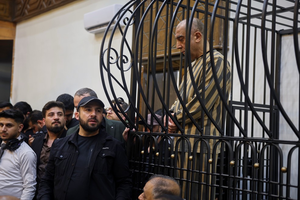 Atef Najib, primo de Bashar al-Assad e ex-chefe do Departamento de Segurança Política de Daraa, aparece em jaula durante julgamento no Palácio da Justiça, em Damasco, na Síria. Foto de 26 de abril de 2026. — Foto: AP Photo/Ghaith Alsayed/Arquivo