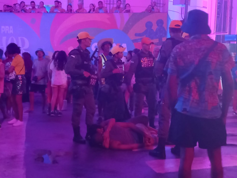 Mulher se agarra a companheiro algemado para evitar prisão no carnaval do Recife — Foto: Luan Amaral/g1