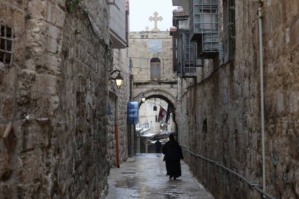 Uma pessoa caminha perto da Igreja do Santo Sepulcro — Foto: REUTERS/Ammar Awad